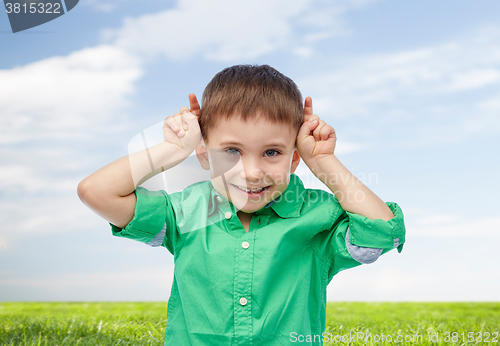 Image of happy little boy having fun and making horns