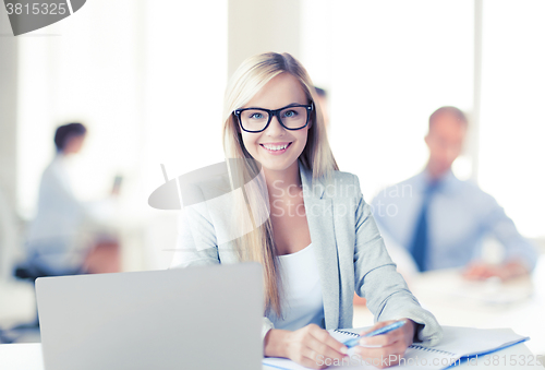 Image of businesswoman with documents in office