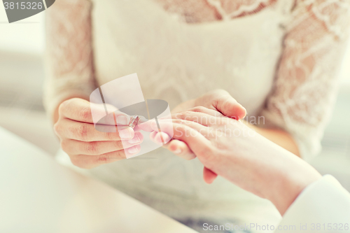 Image of close up of lesbian couple hands with wedding ring