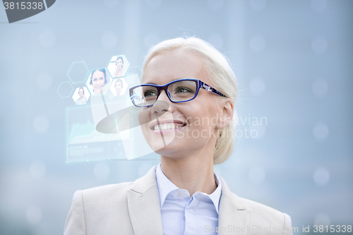 Image of young smiling businesswoman in eyeglasses outdoors