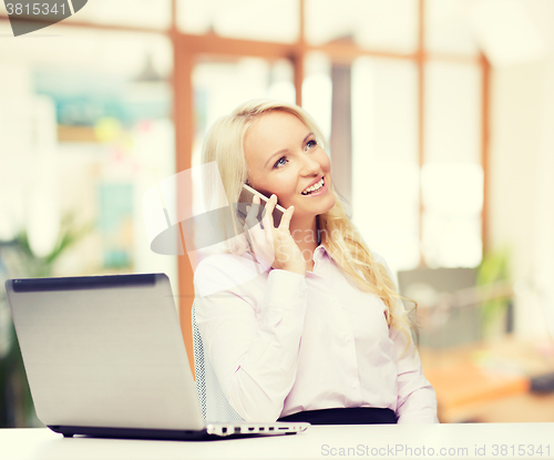 Image of smiling businesswoman calling on smartphone