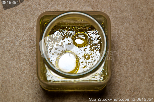 Image of round oil drops in square jar