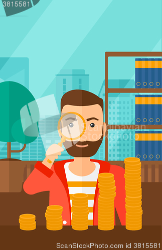 Image of Man with magnifier and golden coins. 