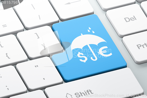 Image of Protection concept: Money And Umbrella on computer keyboard background