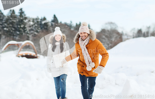 Image of happy couple running over winter background