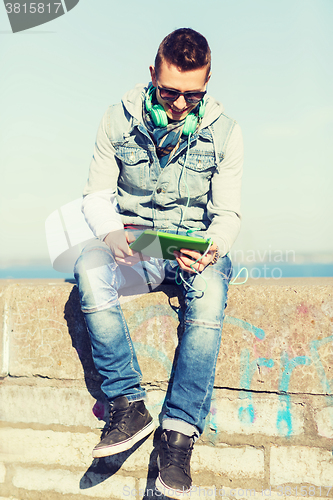 Image of happy young man with tablet pc and headphones