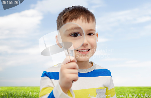 Image of happy little boy looking through magnifying glass