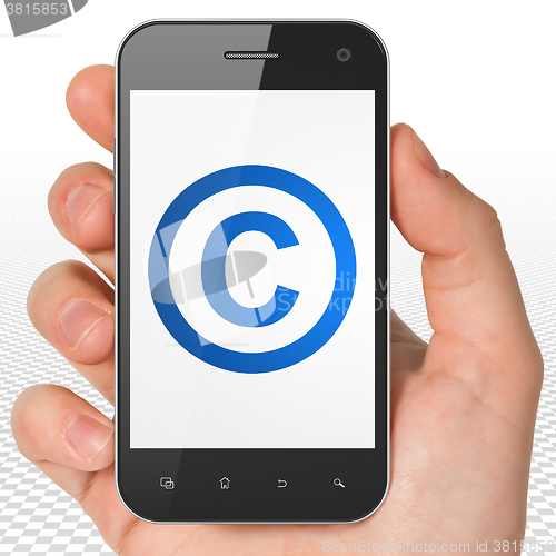 Image of Law concept: Hand Holding Smartphone with Copyright on display