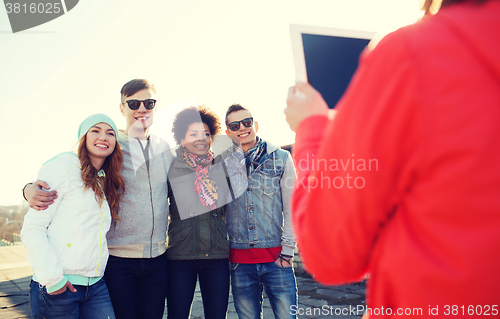 Image of happy teenage friends with tablet pc photographing