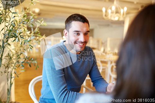 Image of happy couple talking at cafe or restaurant