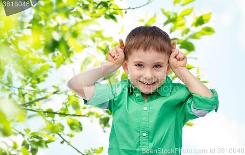 Image of happy little boy having fun and making horns