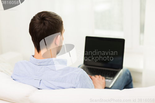 Image of close up of man typing on laptop computer at home