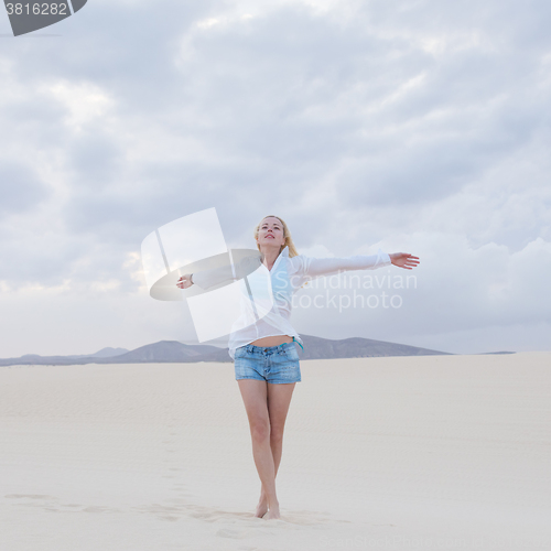 Image of Carefree woman enjoying freedom on beach.