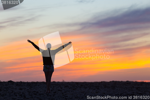 Image of Woman enjoying freedom at sunset.