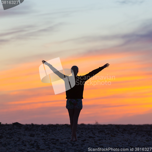 Image of Woman enjoying freedom at sunset.