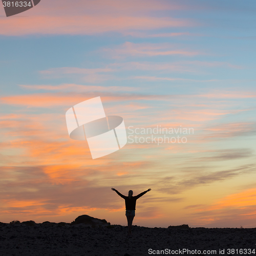 Image of Woman enjoying freedom at sunset.