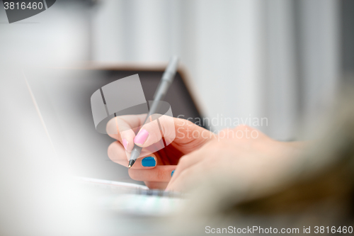 Image of female hands with pen writing on notebook