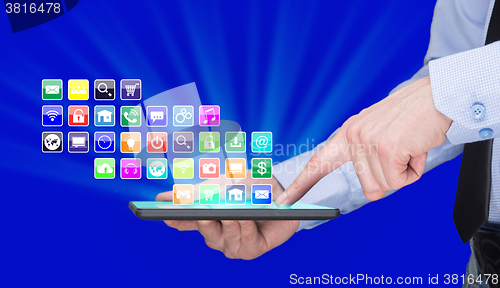 Image of Businessman holding a tablet pc with mobile applications icons on virtual screen . Internet and business concept.