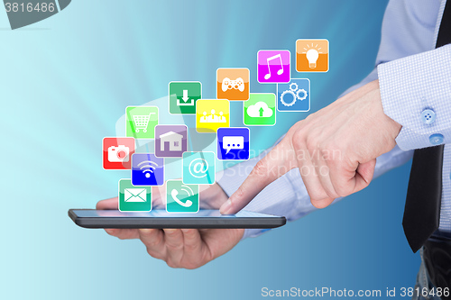 Image of Businessman holding a tablet pc with mobile applications icons on virtual screen . Internet and business concept.