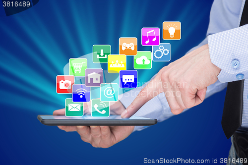 Image of Businessman holding a tablet pc with mobile applications icons on virtual screen . Internet and business concept.