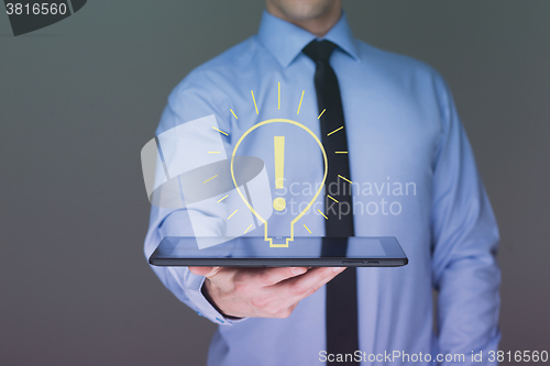 Image of light bulb money on tablet businessman. 