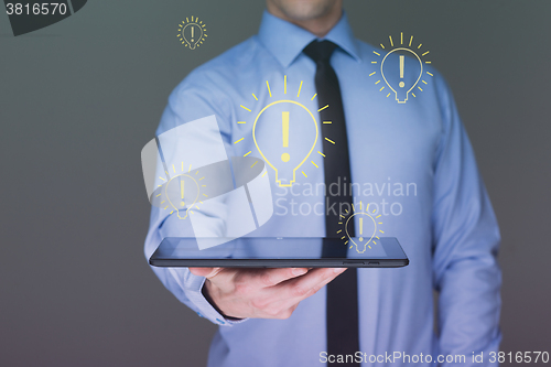 Image of light bulb money on tablet businessman. 