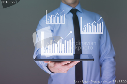 Image of businessman hold tablet with graph on high technology