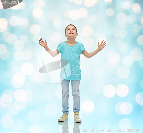 Image of happy little girl looking up to something