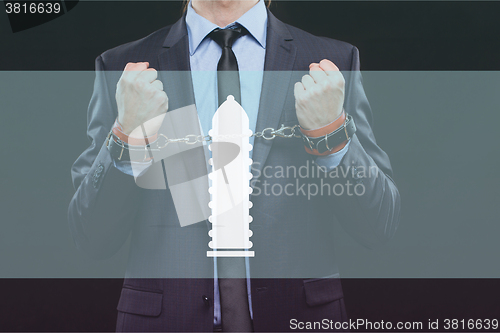 Image of man in a business suit with chained hands. handcuffs for sex games. concept of erotic entertainment.