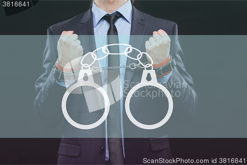 Image of man in a business suit with chained hands. handcuffs for sex games. concept of erotic entertainment.