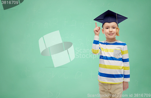 Image of happy boy in bachelor hat pointing finger up