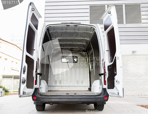 Image of empty minivan car with open doors on city parking