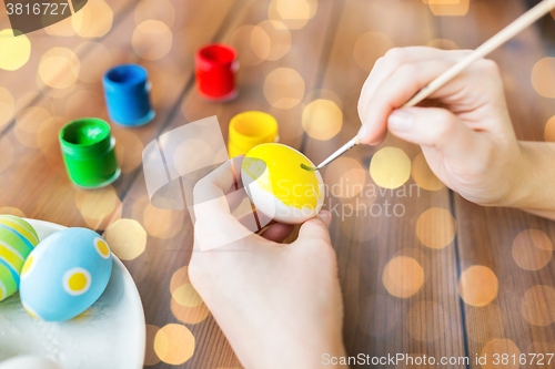 Image of close up of woman hands coloring easter eggs