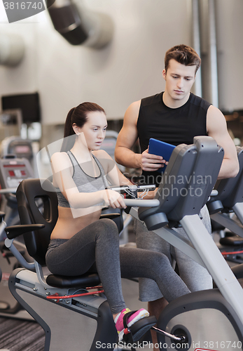 Image of woman with trainer on exercise bike in gym