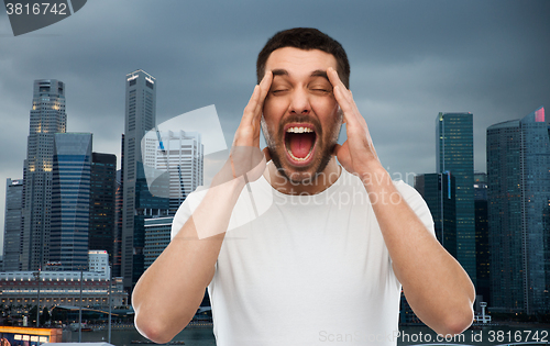 Image of crazy shouting man in t-shirt over singapore city