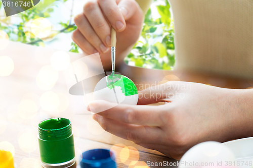 Image of close up of woman hands coloring easter eggs