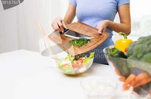 Image of close up of woman with chopped onion cooking salad