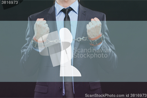 Image of man in a business suit with chained hands. handcuffs for sex games. concept of erotic entertainment.