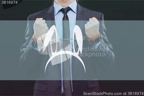 Image of man in a business suit with chained hands. handcuffs for sex games. concept of erotic entertainment.