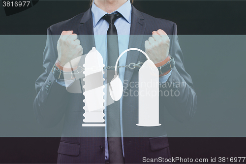 Image of man in a business suit with chained hands. handcuffs for sex games. concept of erotic entertainment.