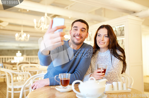 Image of couple taking smartphone selfie at cafe restaurant
