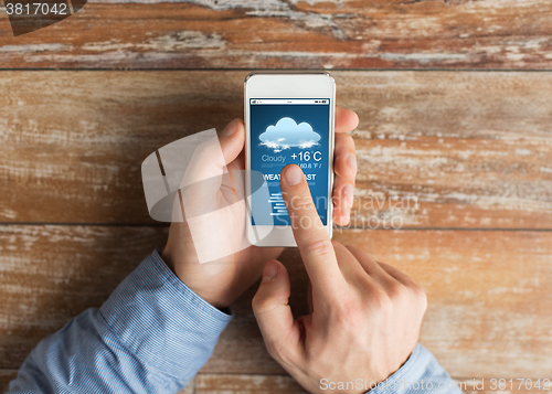 Image of close up of male hands with smartphone on table