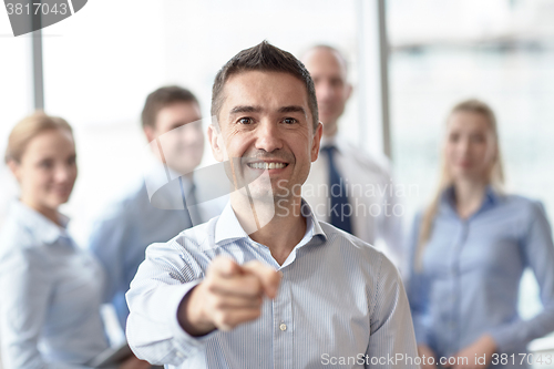 Image of group of smiling businesspeople meeting in office