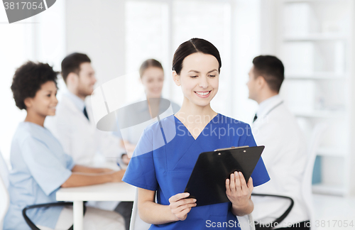 Image of happy doctor over group of medics at hospital