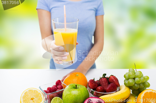 Image of close up of woman holding orange juice with fruits
