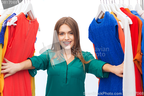 Image of happy woman choosing clothes at home wardrobe