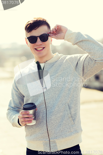 Image of smiling young man or boy drinking coffee