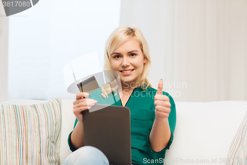 Image of happy woman with tablet pc and credit card