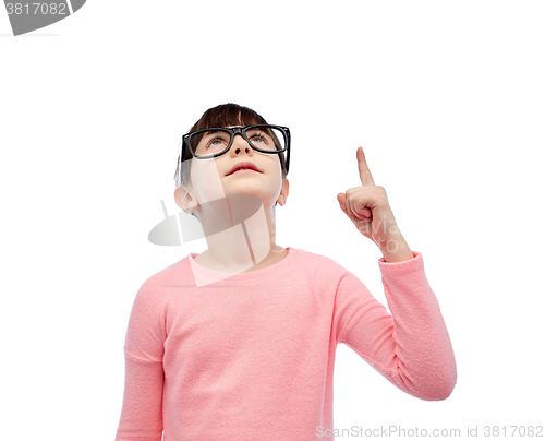 Image of happy little girl in eyeglasses pointing finger up