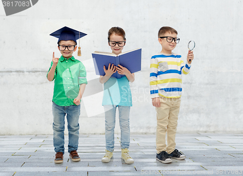 Image of kids in glasses with book, lens and bachelor hat